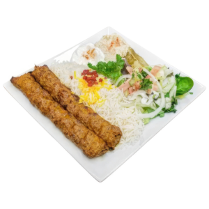 Grilled beef skewers with rice and choice of soup or salad on a plate.